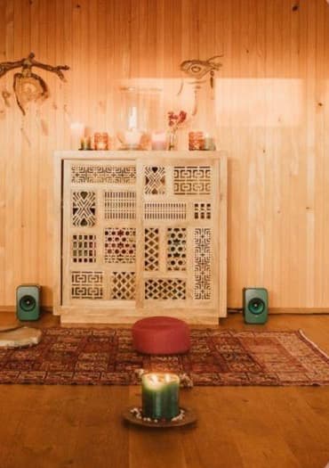Der Raum im Fallenberg Space — warmes Holz, Kerzen und Teppiche.
